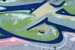 Fragment of graffiti drawings. The old wall decorated with paint stains in the style of street art culture. Colored background texture in green tones photo