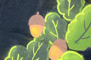 Fragment of graffiti drawings. The old wall decorated with paint stains in the style of street art culture. Oak leaves and acorns photo