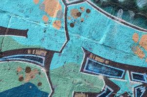 Fragment of graffiti drawings. The old wall decorated with paint stains in the style of street art culture. Colored background texture in cold tones photo