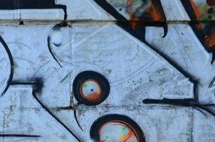 Fragment of graffiti drawings. The old wall decorated with paint stains in the style of street art culture. Colored background texture photo