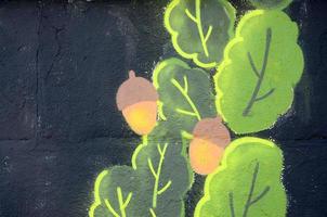 Fragment of graffiti drawings. The old wall decorated with paint stains in the style of street art culture. Oak leaves and acorns photo