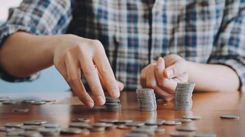 businessman holding coins putting in glass with using calculator to calculate concept saving money for finance accounting, Business, finance, investment, Financial planning. video