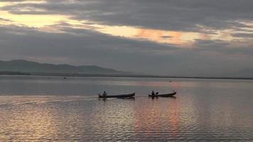 silhouette de pêcheurs profitant d'un beau coucher de soleil dans leur bateau pendant la pêche video