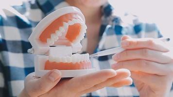 conceito de estomatologia, retrato parcial de menina com fortes dentes brancos, olhando para a câmera e sorrindo, dedos perto do rosto. closeup de jovem no dentista, estúdio, dentro de casa video