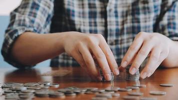 businessman holding coins putting in glass with using calculator to calculate concept saving money for finance accounting, Business, finance, investment, Financial planning. video