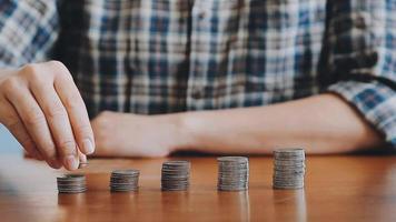 businessman holding coins putting in glass with using calculator to calculate concept saving money for finance accounting, Business, finance, investment, Financial planning. video