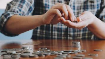 businessman holding coins putting in glass with using calculator to calculate concept saving money for finance accounting, Business, finance, investment, Financial planning. video