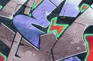 Fragment of graffiti drawings. The old wall decorated with paint stains in the style of street art culture. Colored background texture in purple tones photo