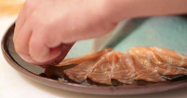 Laying Thin Slices Of Fresh Raw Salmon In A Plate - close up, slow motion video