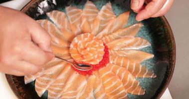 Putting Roe To A Platter Of Salmon Sashimi In A Sushi Restaurant - overhead shot video