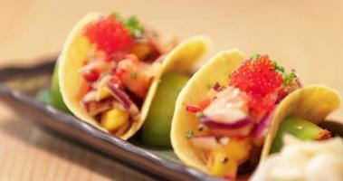 heerlijk taco's in een bord gevulde met gemengd uien en tomaten bekroond met kaviaar - dichtbij omhoog video