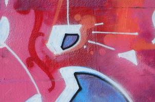 Fragment of graffiti drawings. The old wall decorated with paint stains in the style of street art culture. Colored background texture in warm tones photo