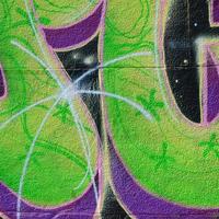 Fragment of graffiti drawings. The old wall decorated with paint stains in the style of street art culture. Colored background texture in green tones photo