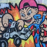 fragmento de dibujos de graffiti. la antigua muralla decorada con manchas de pintura al estilo de la cultura del arte callejero. niño rompe juguetes de policía foto