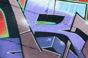 Fragment of graffiti drawings. The old wall decorated with paint stains in the style of street art culture. Colored background texture in purple tones photo