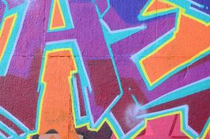 Fragment of graffiti drawings. The old wall decorated with paint stains in the style of street art culture. Colored background texture in purple tones photo