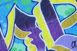 fragmento de dibujos de graffiti. la antigua muralla decorada con manchas de pintura al estilo de la cultura del arte callejero. textura de fondo coloreada en tonos fríos foto