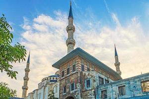 View of the minarets of a mosque in Istanbul from the ground perspective against the blue sky in the background photo