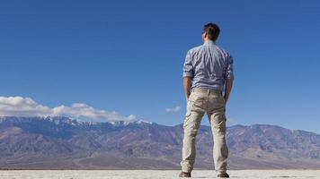 Shot of man from behind against imposing mountain backdrop photo
