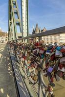 Love locks on bridge Eiserner Steg in Frankfurt with skyline and Main river in background photo