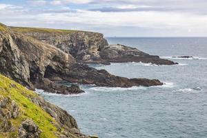 Rough cliff line at Mizen head lighthouse in southern west Ireland during daytime photo
