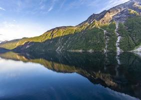 impresión de un crucero en el camino a través del fiordo de geiranger en noruega al amanecer en verano
