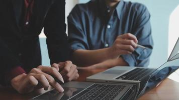 colegas asiáticos hombre y mujer discutiendo y trabajando con una computadora portátil en el escritorio de la oficina video