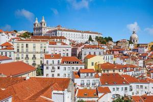 imagen sobre los tejados de la ciudad vieja de lisboa con la iglesia de sao vicennte de fora y la igreja de santa engracia en verano foto