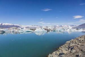 Panoramic pictures over Joekularson glacier lagoon with frifting iceberg in summer during daytime photo