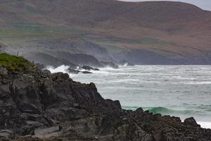 Rough breaking of waves on Irish coast line during daytime photo