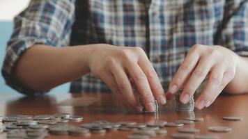 homme d'affaires détenant des pièces de monnaie mettant dans du verre avec une calculatrice pour calculer le concept d'économie d'argent pour la comptabilité financière, les affaires, la finance, l'investissement, la planification financière. video