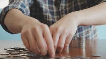 homme d'affaires détenant des pièces de monnaie mettant dans du verre avec une calculatrice pour calculer le concept d'économie d'argent pour la comptabilité financière, les affaires, la finance, l'investissement, la planification financière. video