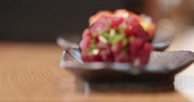Thunfisch-Temaki-Sushi - Hand eines Kochs legte den Sushi-Kegel oder die Handrolle in einen Teller. - Rack-Fokus-Aufnahme, Zeitlupe video