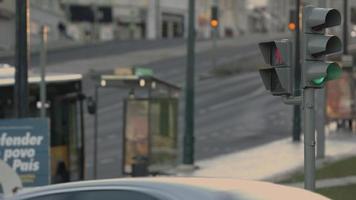 visão mais próxima dos semáforos mudando no cruzamento em lisboa, portugal com pessoas e veículos no fundo desfocado - lapso de tempo video