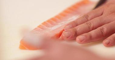 cortando o excesso de carne de filé de salmão fresco - fabricação de sushi - close-up, câmera lenta video