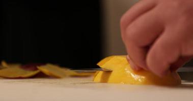 Sushi capocuoco affettare Mango e ambientazione a parte su un' chopping tavola. - vicino su tiro video