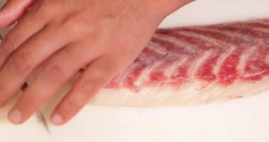 capocuoco taglio carne di fresco crudo pesce nel lento movimento per Sushi fabbricazione nel un' giapponese ristorante - alto angolo sparo, vicino su video