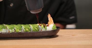 relleno de rollos de sushi de tempura de camarones preparados con salsa de anguila - primer plano panorámico, cámara lenta video