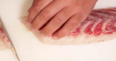 pescado fresco cuidadosamente cortado en rodajas de precisión para sashimi - primer plano