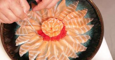 vue de dessus du sashimi de saumon en forme de fleur avec du caviar rouge disposé sur une assiette - prise de vue en grand angle video