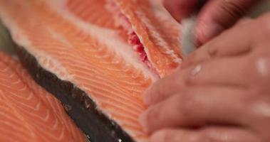 Deboning Raw Salmon For Sushi - close up, slow motion video