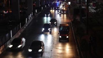 blurred video view of night traffic on the city streets of Bangkok, the capital city of Thailand's densely populated business and financial center, and many tourist destinations.