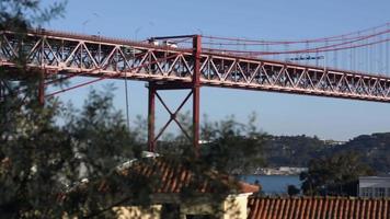 bianca furgone guida su il bellissimo abril ponte nel Portogallo su un' luminosa soleggiato giorno - largo padella tiro video