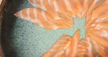 Teller mit frischem Lachsfilet, serviert in einem japanischen Restaurant - Lachs-Sashimi-Gericht. - hoher Winkel - Schwenk video