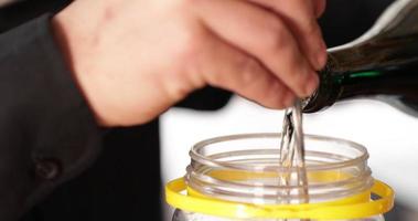 Pouring White Wine Into A Glass Jar At The Restaurant Kitchen - close up video
