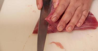 frischer Thunfisch, der mit einem scharfen Messer für Sushi geschnitten wird. - Nahaufnahme von oben nach unten video