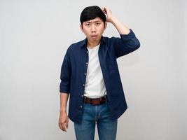 Asian man standing gesture scratch head feels doubt and confused isolated photo