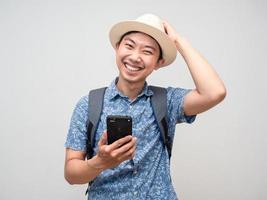 Tourism young man blue shirt hold mobile phone with happy smile feels shy isolated photo