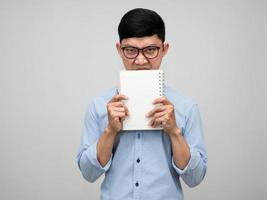 Young manager man holding the book close his face looking at you isolated photo