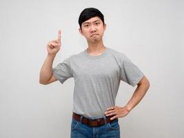 apuesto hombre asiático mirando líder gesto señalar con el dedo hacia arriba confiado rostro aislado foto